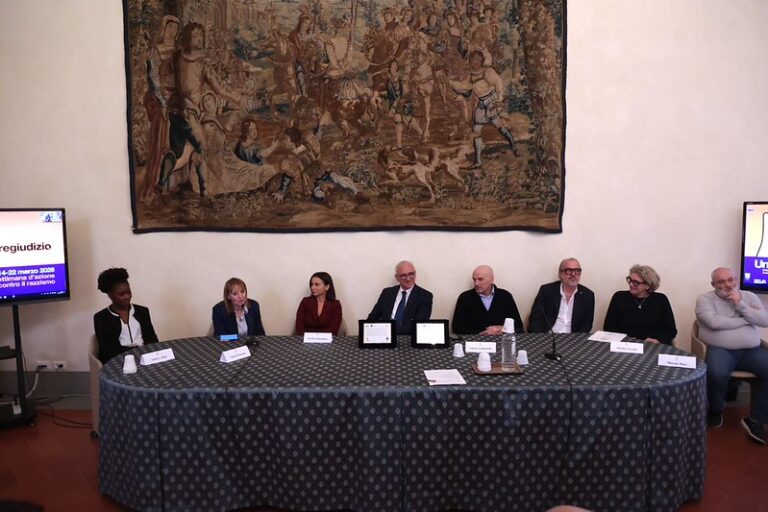 tavolo dei relatori in sala pistelli; alle spalle arazzo