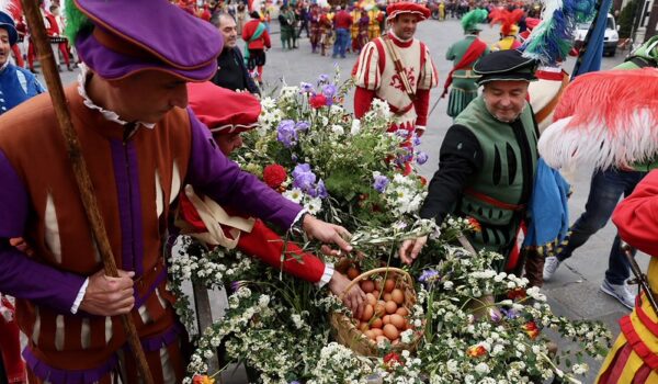 figuranti del corteo storico in abiti rinascimentali con al centro cesto di uova
