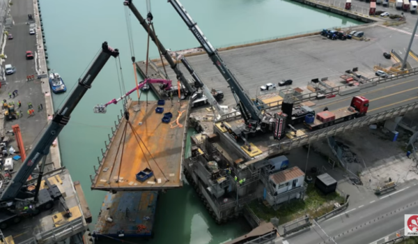 Frame dal video Florence Tv ch mostra la ricollocazione di un settore di ponte con grandi gru