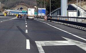 corsie autostradali, segnaletica, imbocco di tunnel sullo sfondo