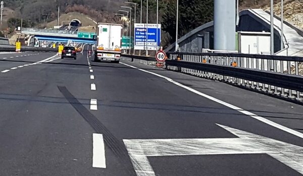 corsie autostradali, segnaletica, imbocco di tunnel sullo sfondo