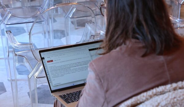 visione di spalle di donna seduta con pc sulle ginocchia in sala pistelli