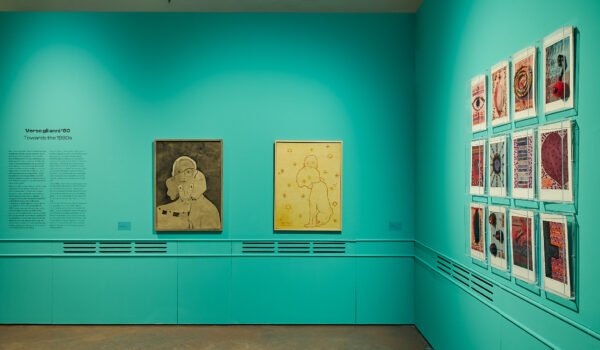 porzione dell'esposizione, pareti verde acqua con tele