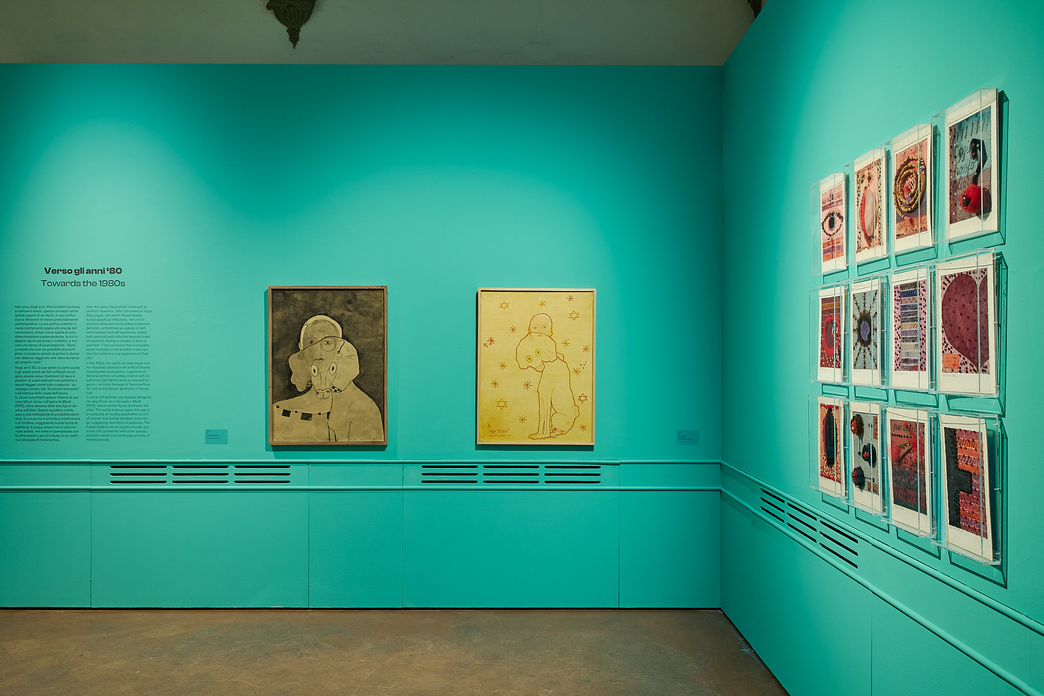 porzione dell'esposizione, pareti verde acqua con tele