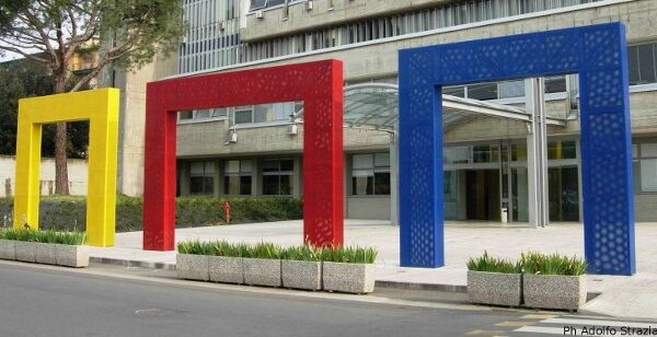 tre archi in metallo in colore diverso (giallo rosso e blu) incorniciano l'ingresso del comune di Scandicci
