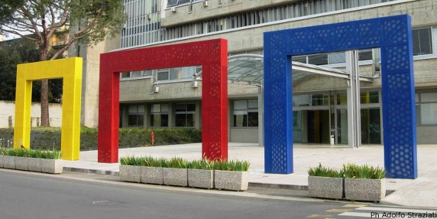 tre archi in metallo in colore diverso (giallo rosso e blu) incorniciano l'ingresso del comune di Scandicci