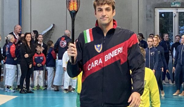 in palestra, primo piano del nuotatore Filippo Megli che porta la fiaccola