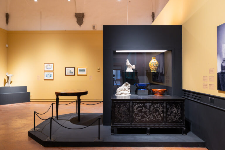 spazio espositivo con ceramiche e quadri alle pareti