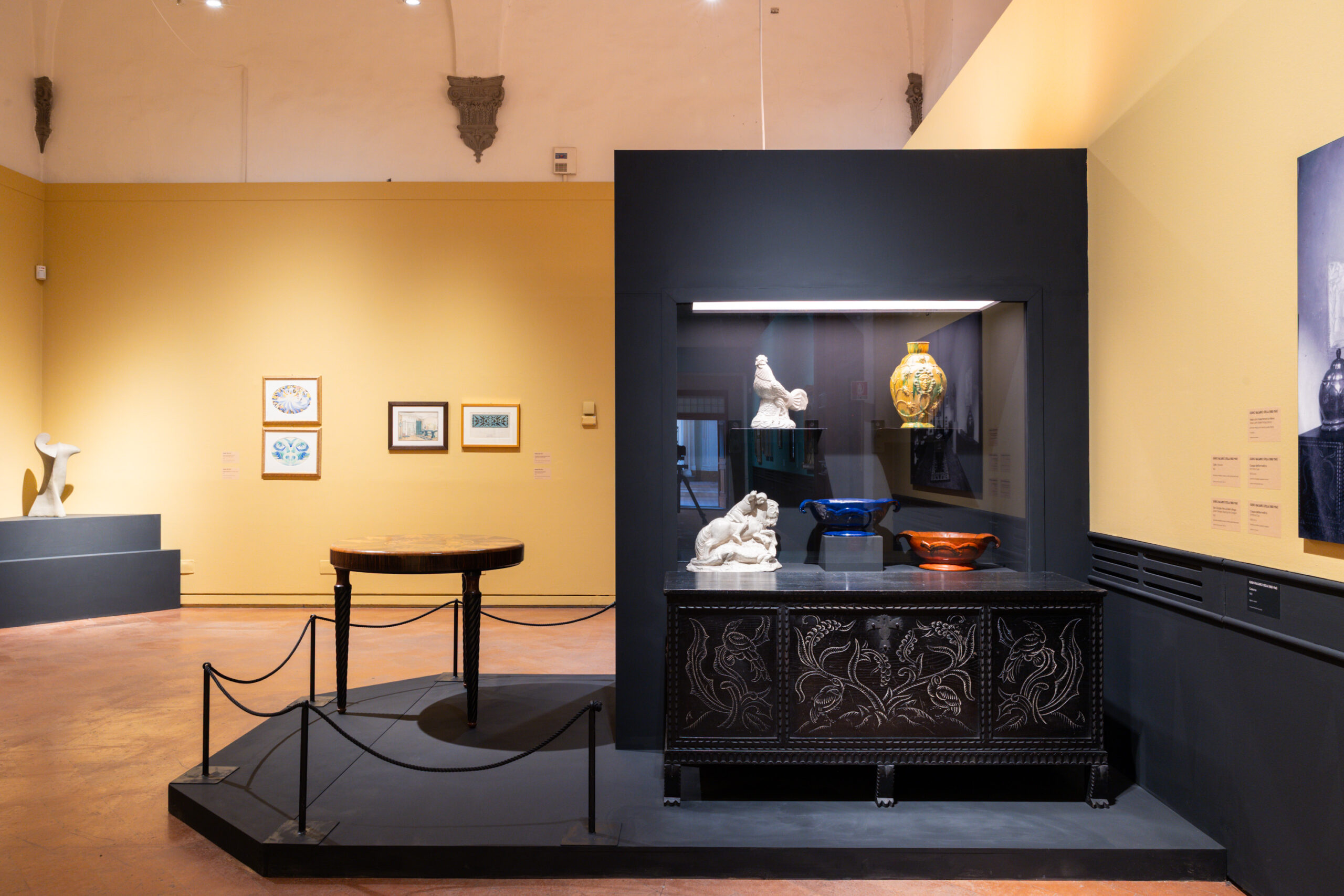 spazio espositivo con ceramiche e quadri alle pareti