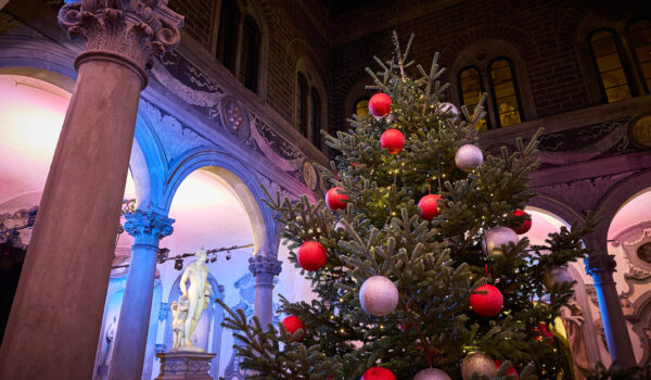 dettaglio di albero di natale con palle rosse e bianche nel cortile illuminato di Michelozzo