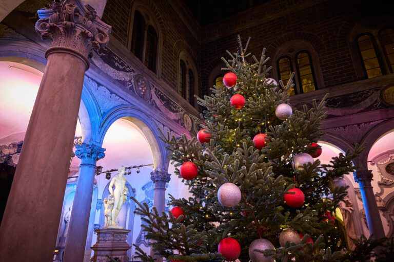 dettaglio di albero di natale con palle rosse e bianche nel cortile illuminato di Michelozzo