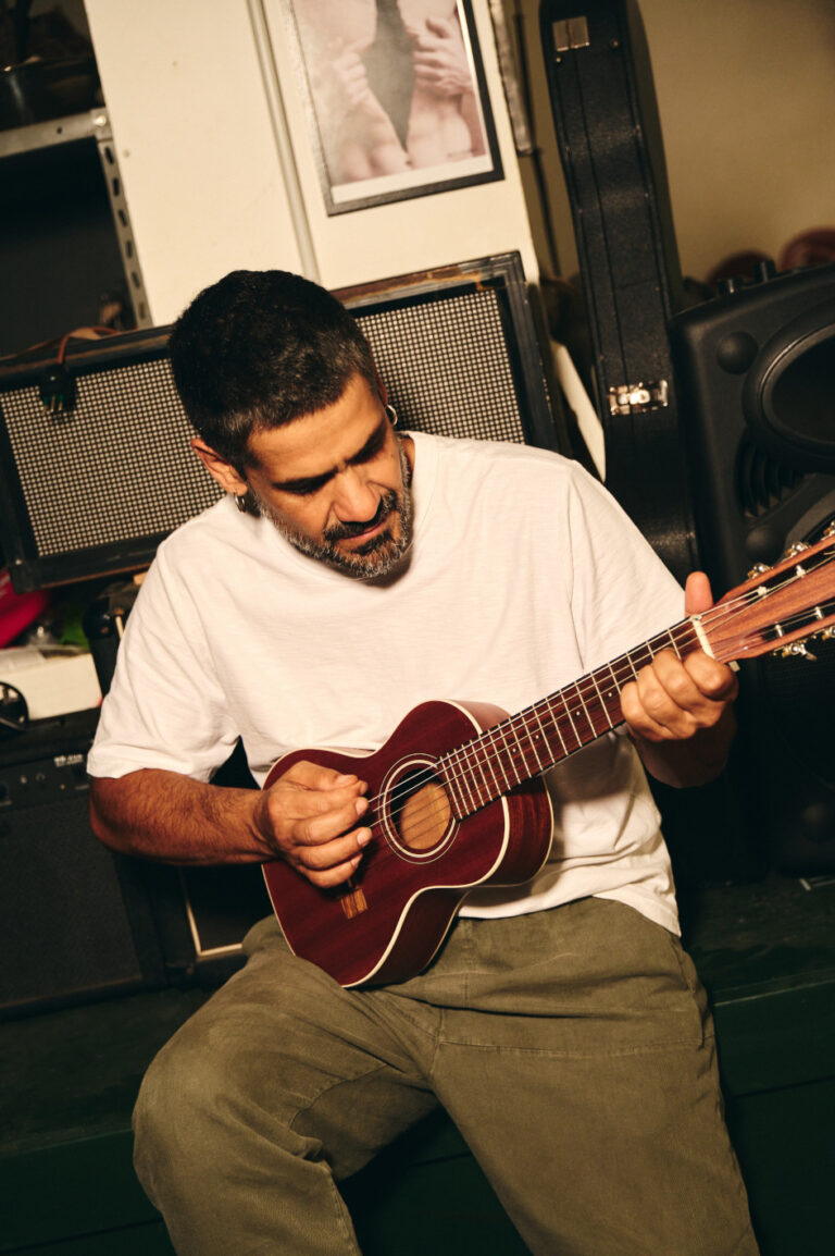 il cantante Mannarino mentre suona una piccola chitarra