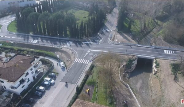 visione dall'alto di strada con incrocio, abitazioni sulla sinistra e ponte sulla destra
