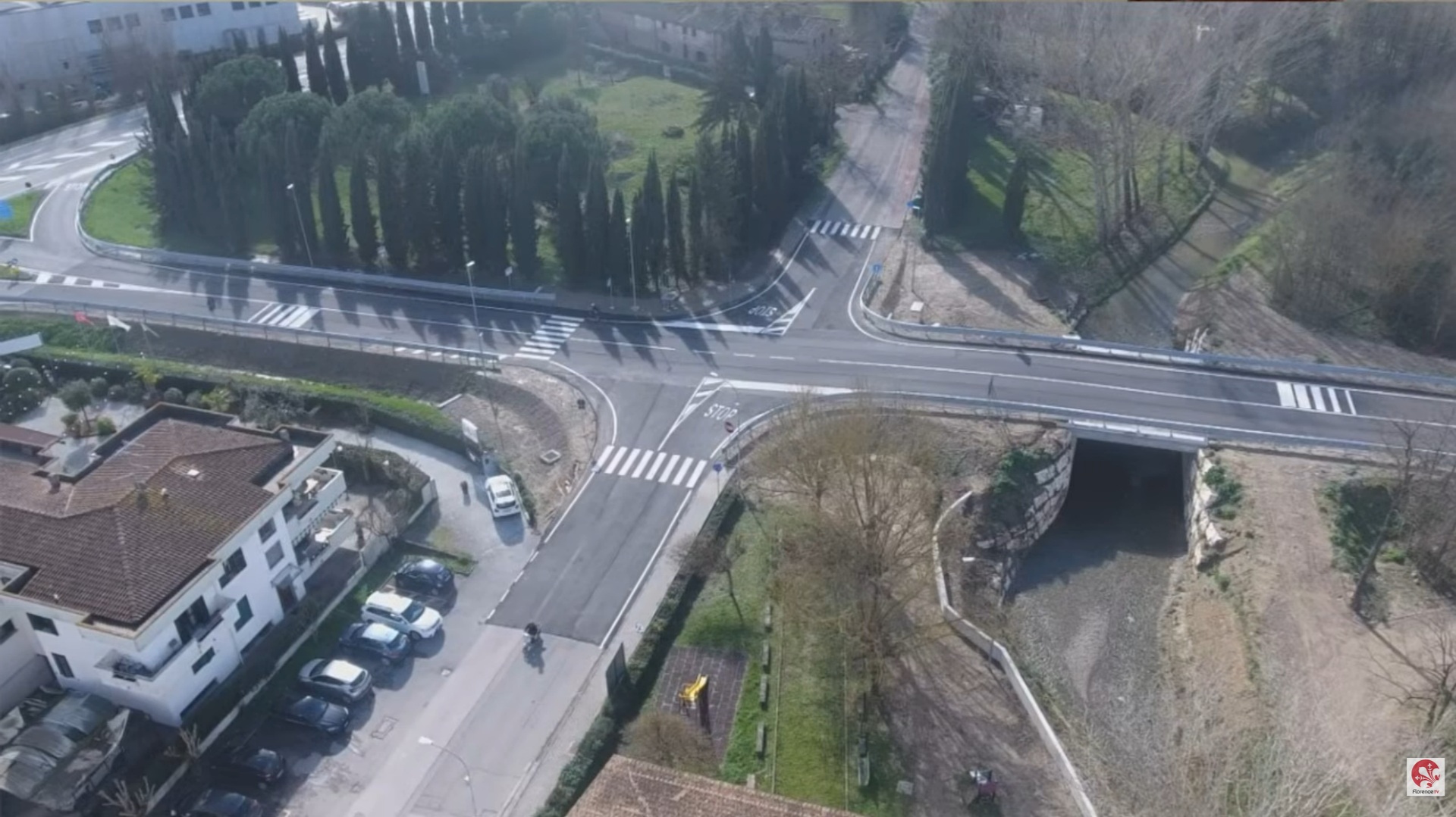 visione dall'alto di strada con incrocio, abitazioni sulla sinistra e ponte sulla destra
