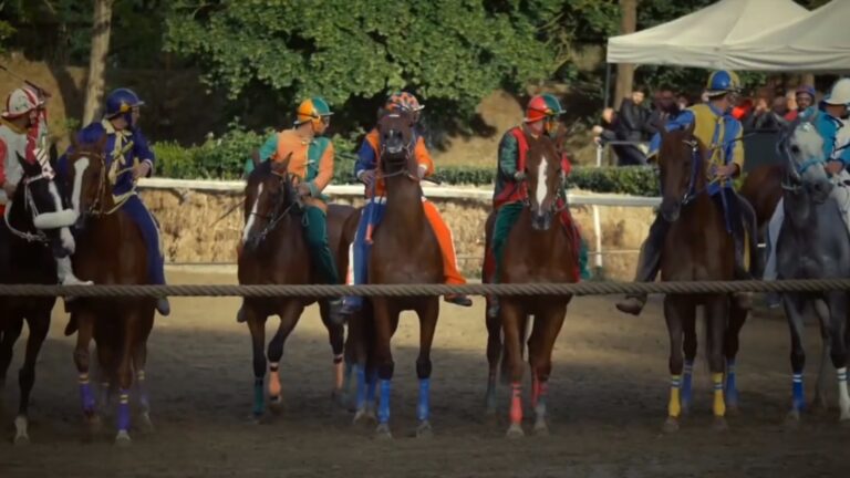 cinque fantini con cavalli al nastro di partenza