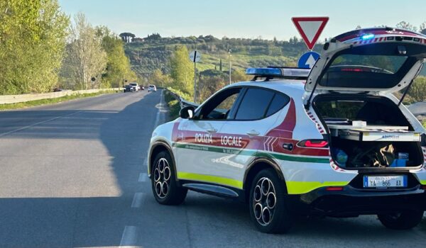 Veicolo della Polizia locale metropolitana al margine di una strada extraurbana
