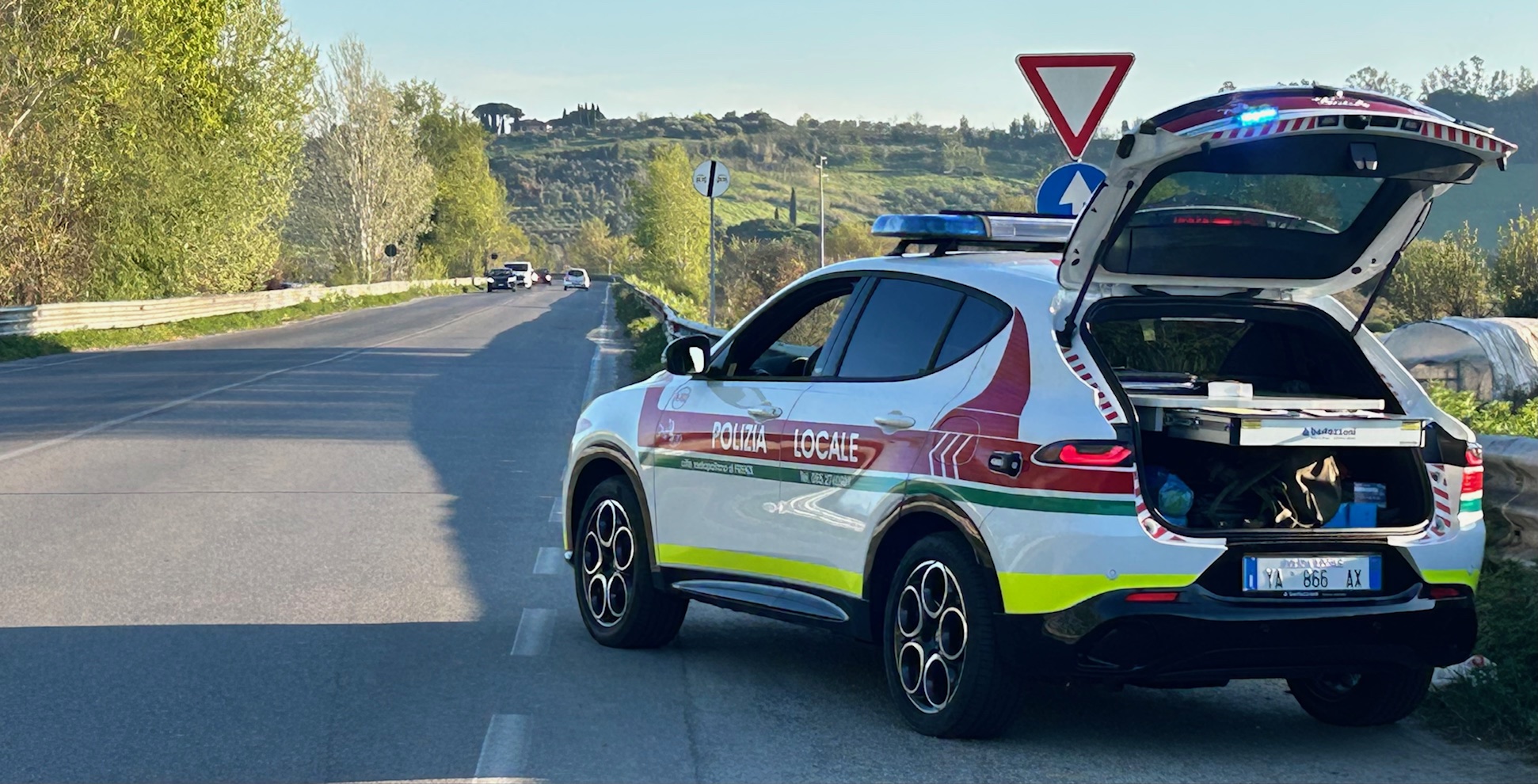 Veicolo della Polizia locale metropolitana al margine di una strada extraurbana