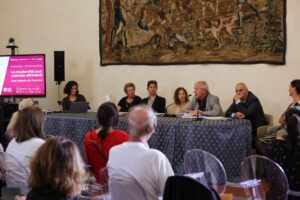 tavolo dei relatori, alle loro spalle arazzo