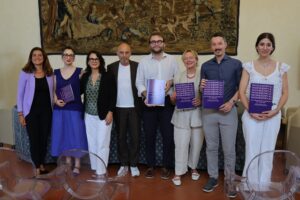 con arazzo alle spalle, in piedi gli 8 relatori intervenuti alla presentazione del progetto