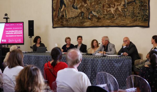 tavolo dei relatori, alle loro spalle arazzo
