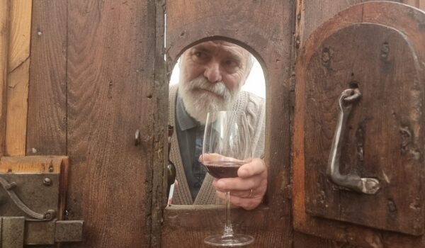 mano con calice spunta da sportellino in portone antico