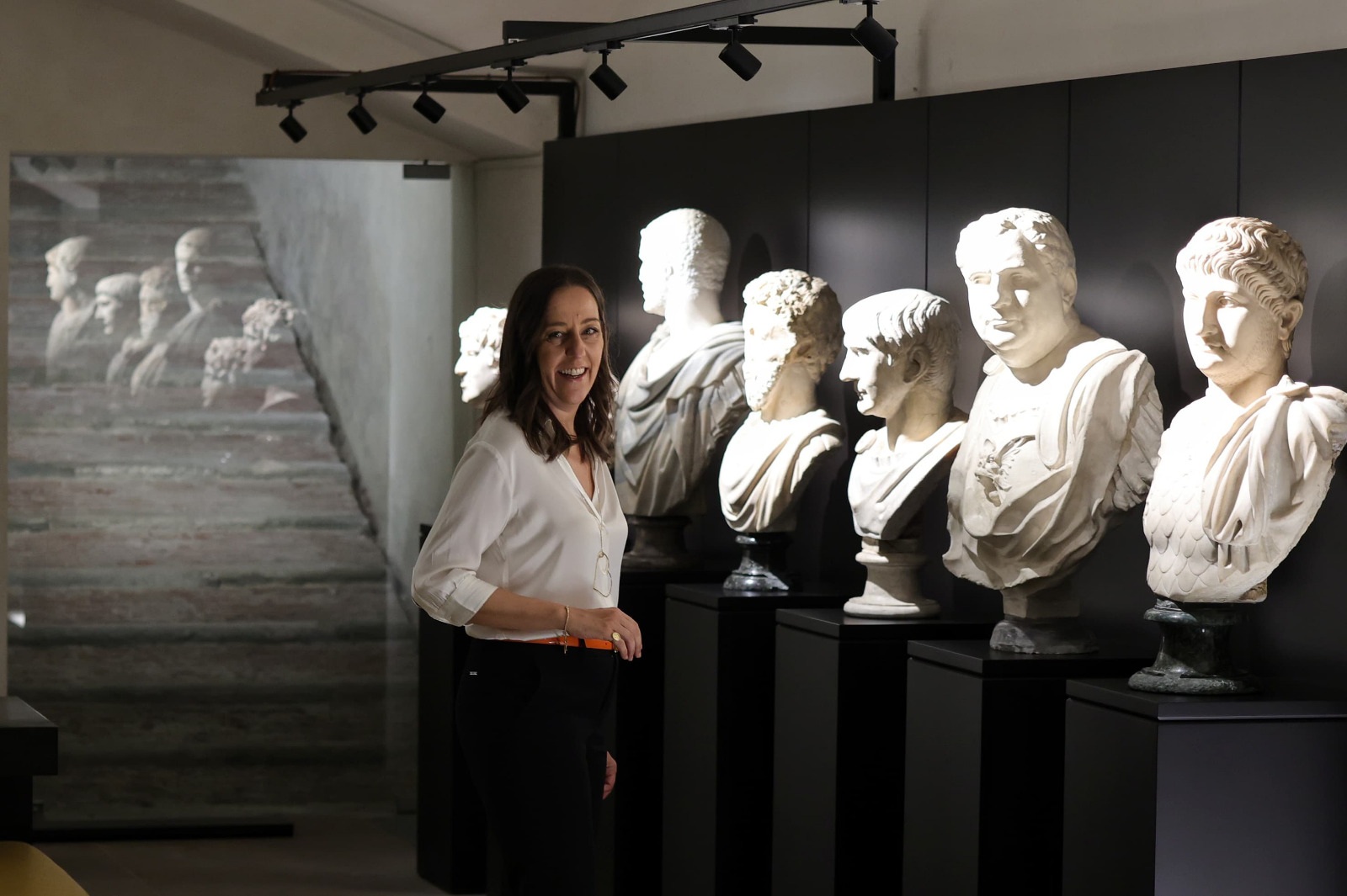 la sindaca Funaro in una sala del museo dei marmi riallestito: sindaca a sinistra, sulla destra 5 busti in marmo di epoca romana